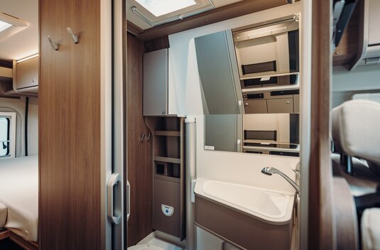 Carado motorhome bathroom with washbasin, mirror and wooden cabinet in the interior