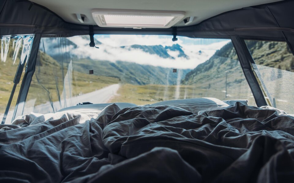 Wake up to a view of the mountain valley and the road from your bed in the Carado motorhome