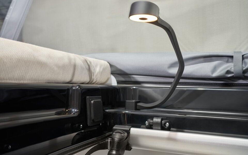 Bedside reading light in the Carado motorhome, close-up of the mattress and sleeping area