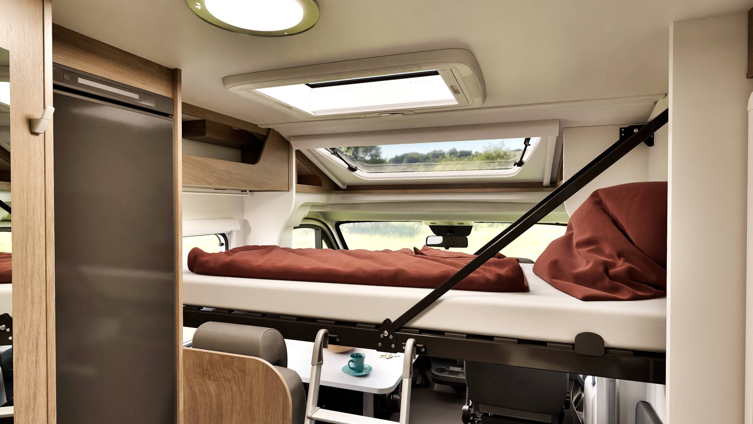 Carado motorhome interior with drop-down bed over the cab, ladder, roof window and refrigerator
