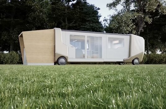 Concept vehicle with fold-out living module on a meadow, side view in front of trees