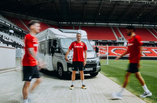 Football player in front of a Carado motorhome at the stadium, with a ball