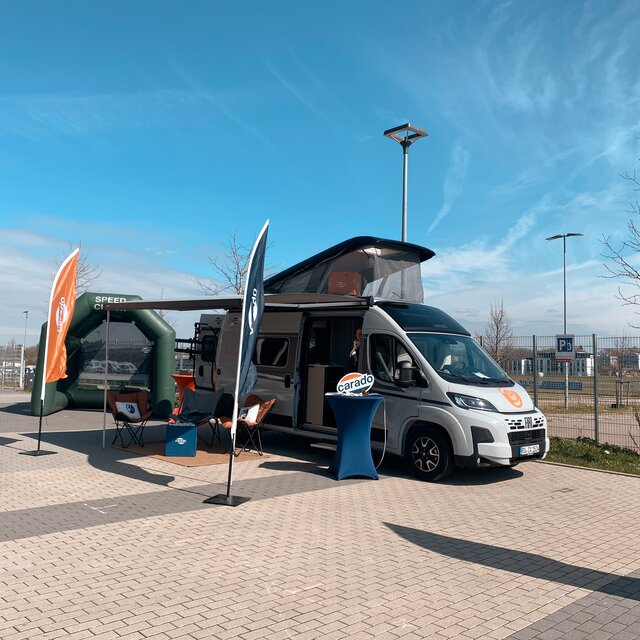 Carado camper van with pop-up roof and awning on a paved display area