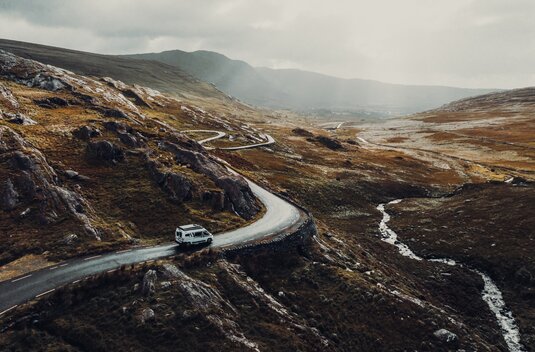 Carado motorhome on a winding mountain road through rocky scenery