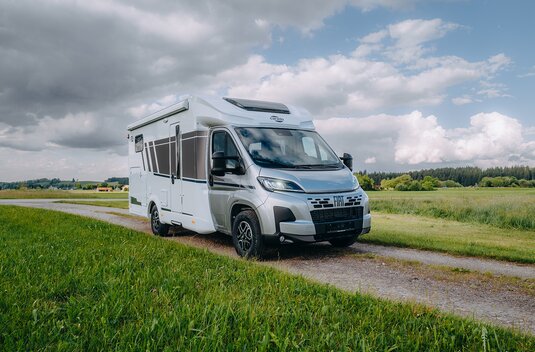 Carado motorhome on a Fiat chassis on a country lane, three-quarter view in a rural setting