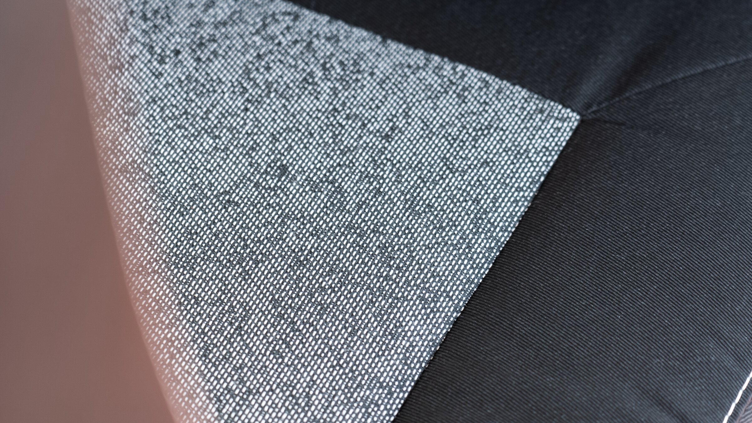 Close-up of grey upholstery fabric with a pattern, next to black fabric with decorative stitching in the Carado motorhome