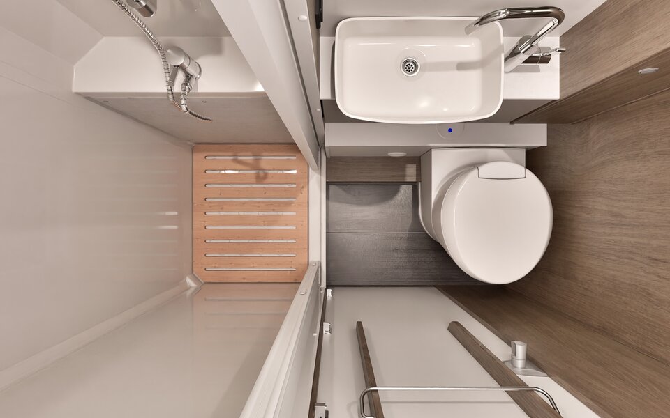 Bathroom in the Carado motorhome with shower, washbasin, toilet and wooden slatted floor