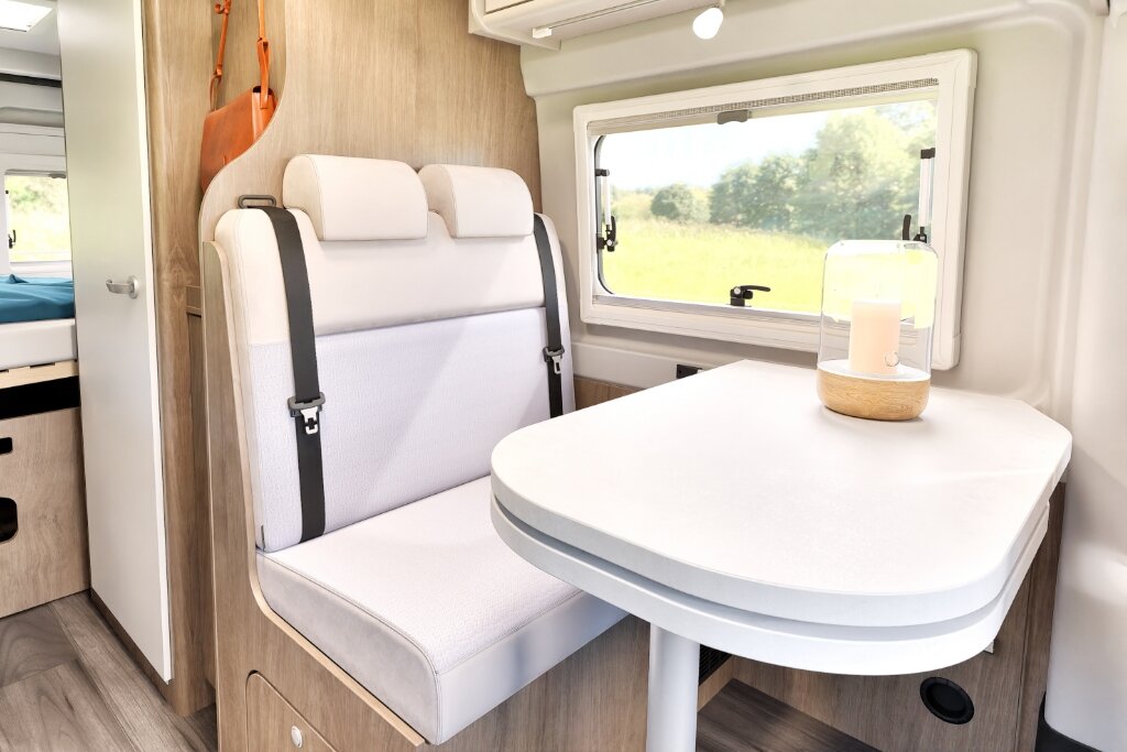 Seating area in the Carado motorhome with two-seat bench, table and window