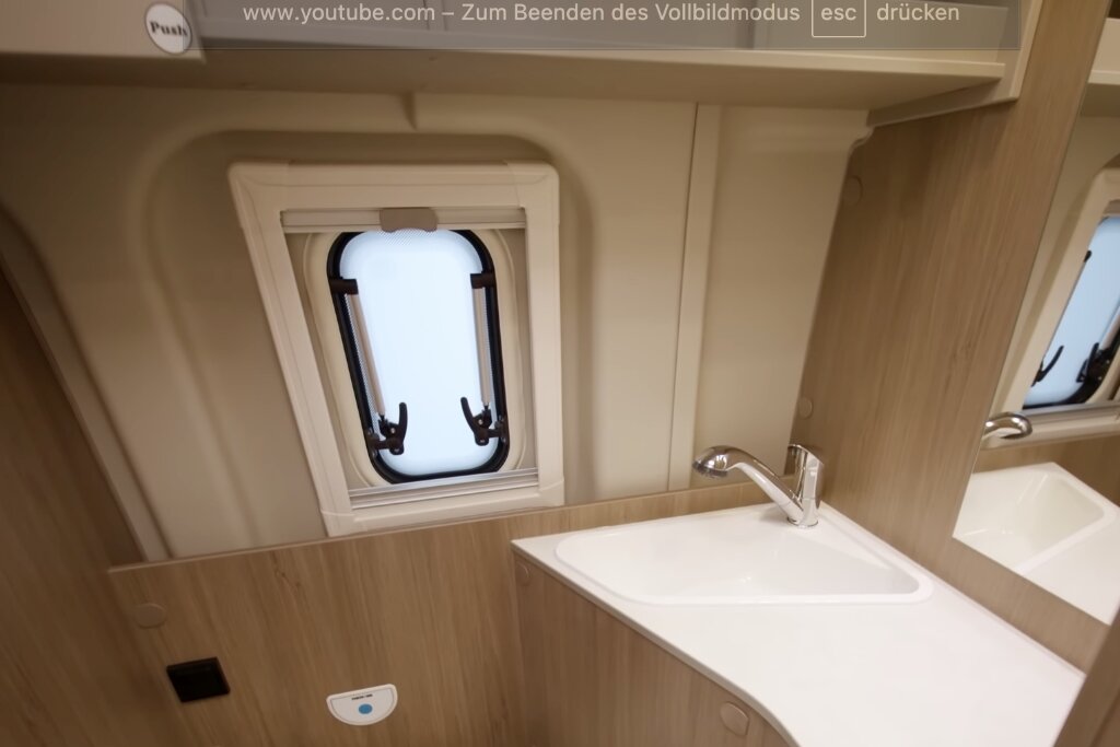 Bad im Carado Wohnmobil mit Waschbecken, Spiegel und kleinem Fenster
