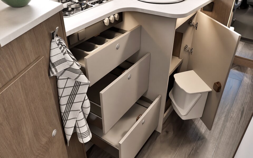 Carado motorhome kitchen with open drawers, a cupboard compartment and a waste bin on the cupboard door