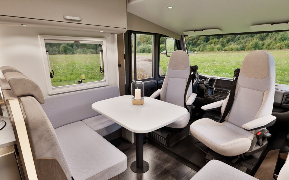 Carado motorhome interior with a seating area, table and swivel cab seats