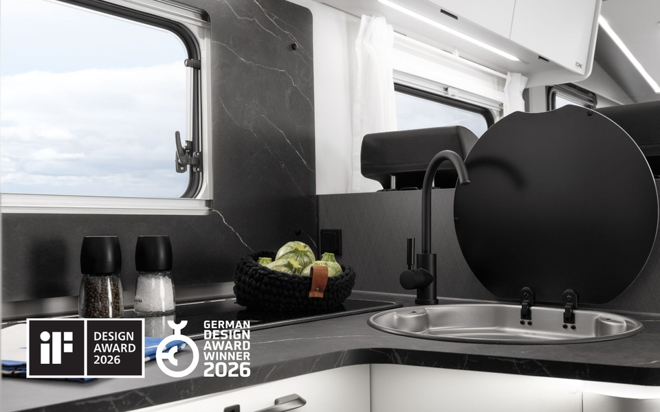 Modern kitchen in the Etrusco motorhome with a cutting board, melon, herbs, and a two-burner gas stove, ideal for camping.