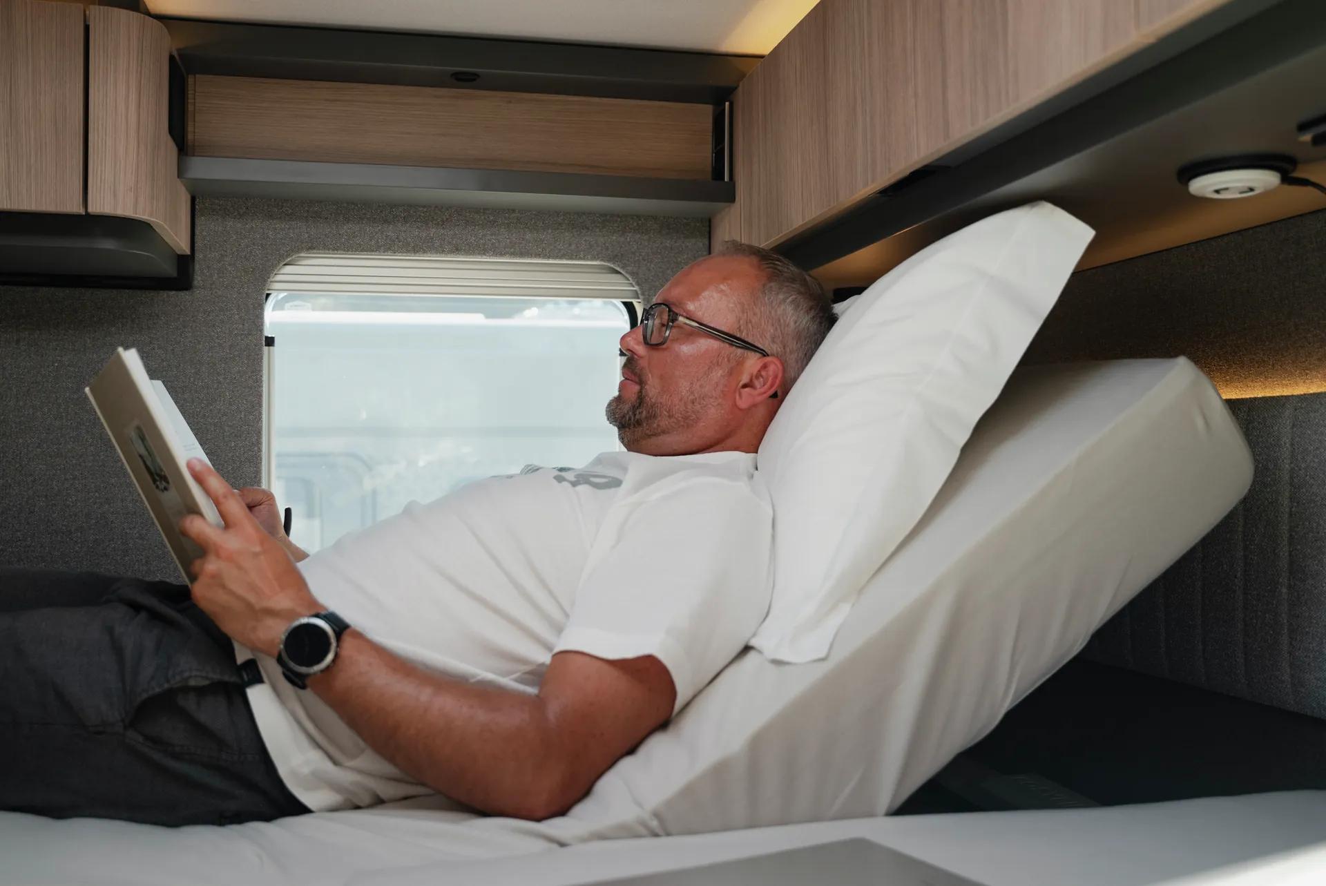 Lesen, entspannen, ankommen: Das elektrisch verstellbare Kopfteilsystem passt die Liegeposition per Handschalter individuell an. Erhältlich über Hymer Original Parts.