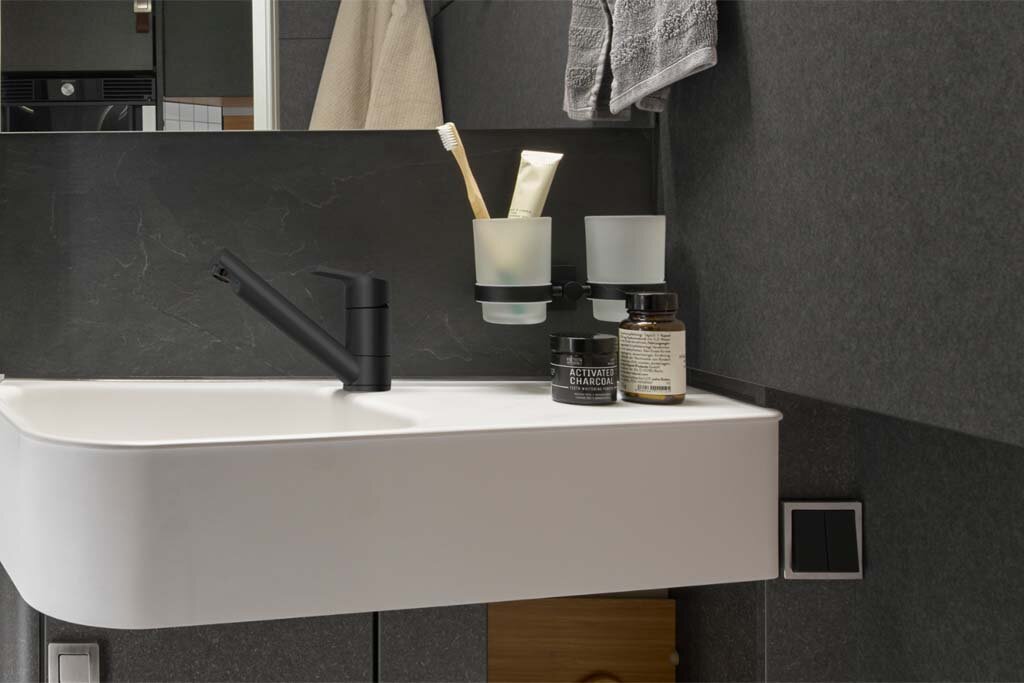 All walls around the sink in the bathroom of the HYMER ML-T are in slate effect.