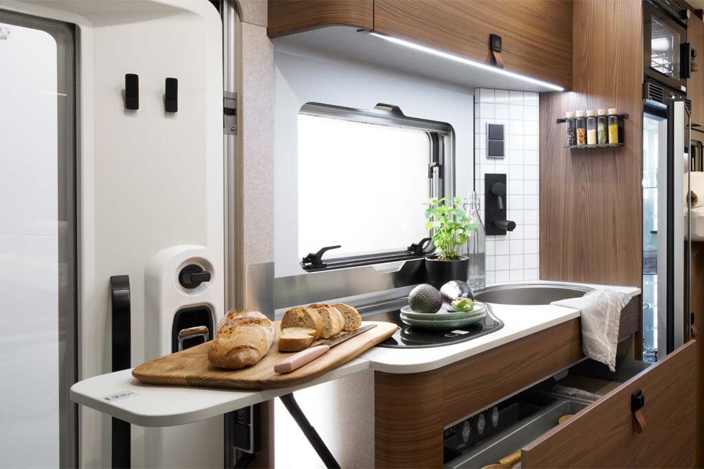 On the kitchen extension in the HYMER ML-T in the Velvet Ash style world, there is bread. In the background, you can see the entire kitchenette and the window.