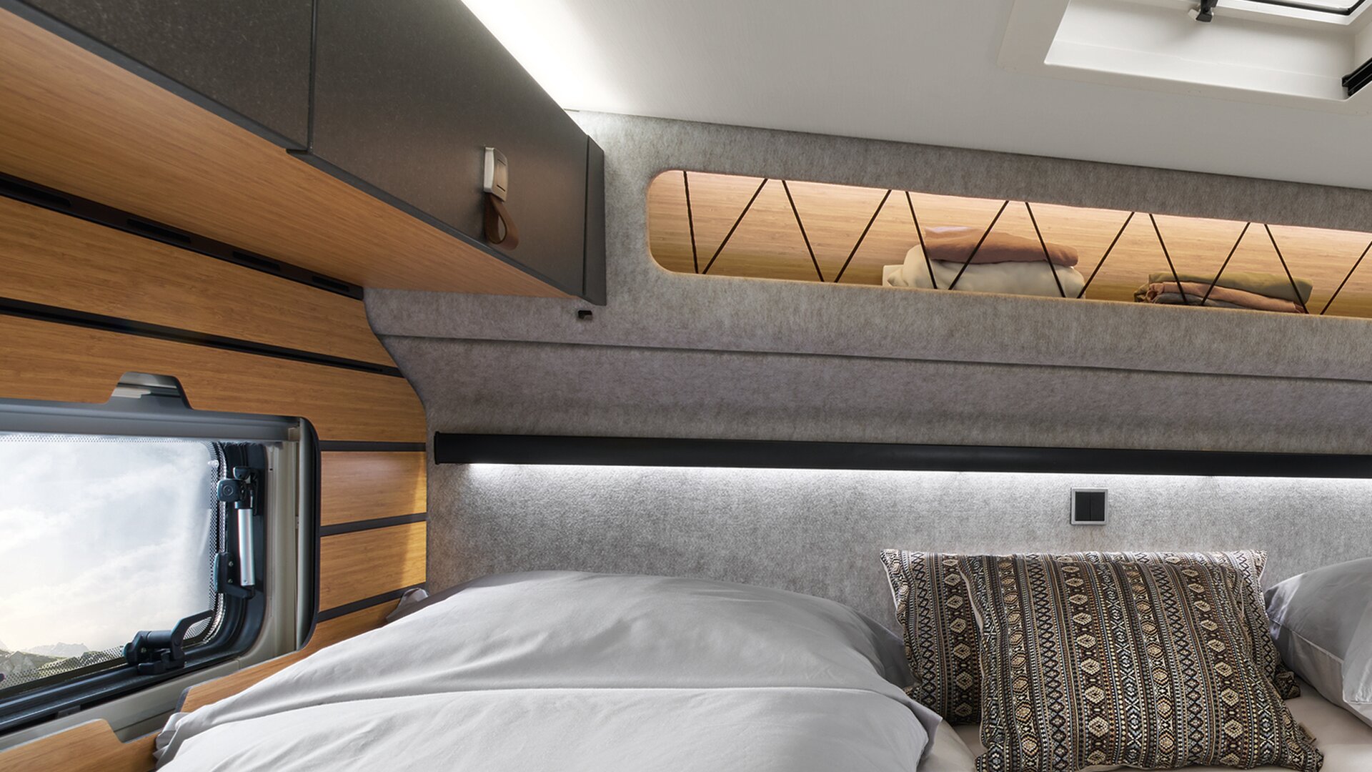 Overhead cabinets are attached around the bed in the HYMER ML-T in the Native Bamboo style world.