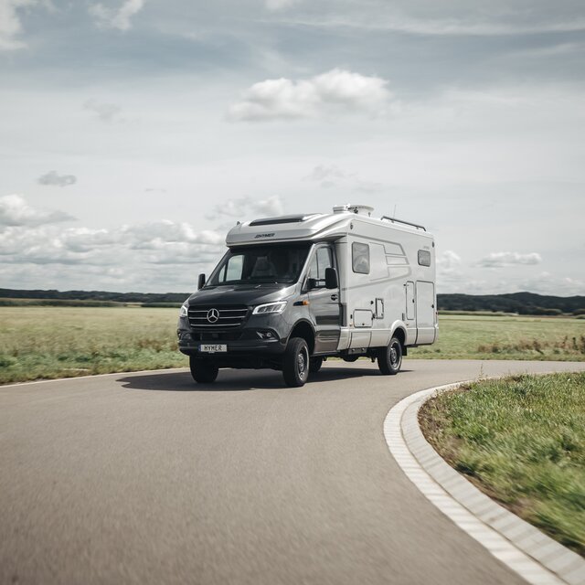 The HYMER ML-T is seen head-on, navigating a curve.
