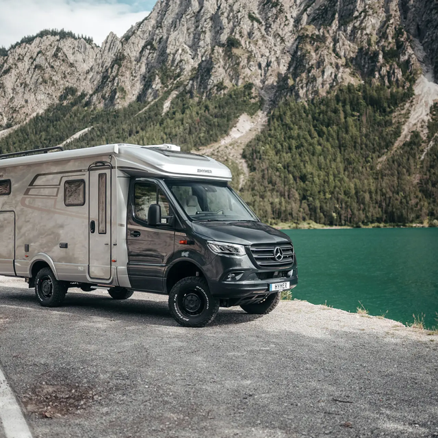 The HYMER ML-T is slightly turned in front of a mountain lake.