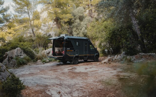 View from the rear side of the Venture S, with the Sunset Deck extended, surrounded by trees.