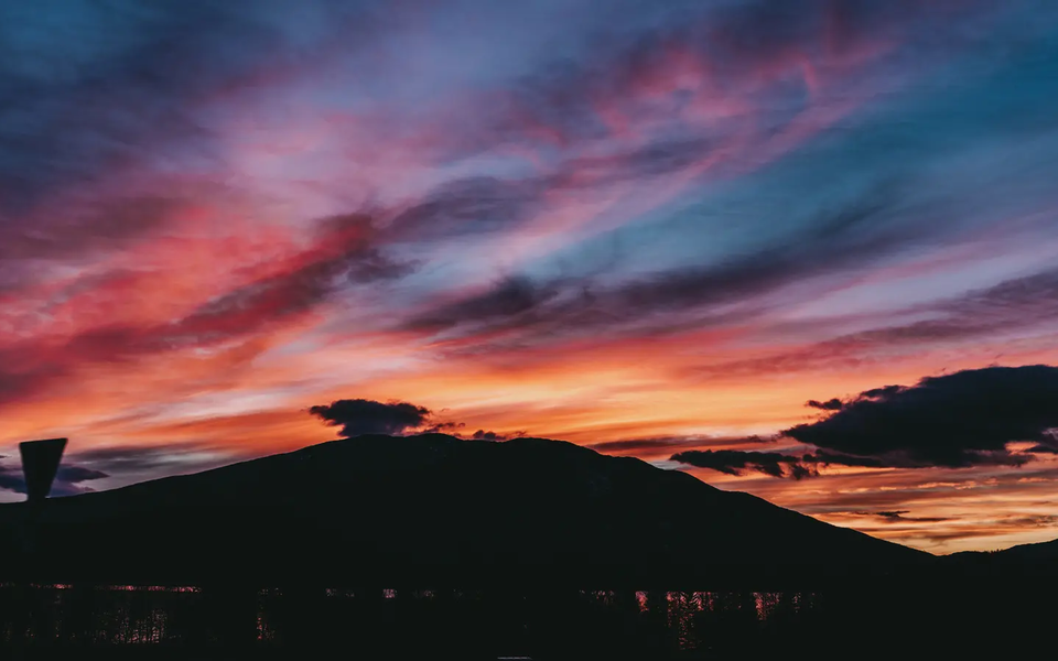 Udsigt over en smuk solnedgang, et bjerg er synligt i baggrunden.