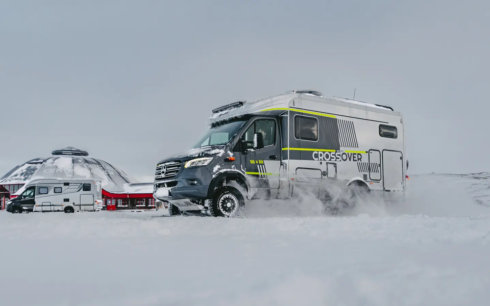 Sideudsigt af førersiden af HYMER ML-T CrossOver, køretøjet er parkeret i sneen, HYMER B-MC T BlackLine i baggrunden
