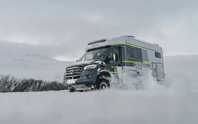 Diagonal udsigt fra højre forside af HYMER ML-T 570 CrossOver, kører gennem et vinterligt sneklædt landskab