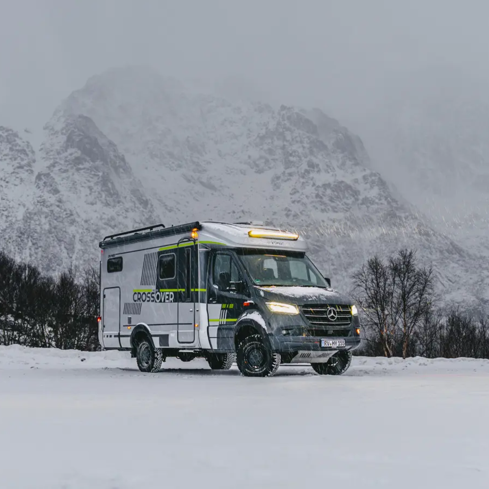 Sideudsigt af HYMER ML-T 570 CrossOver, høje sneklædte bjerge i baggrunden