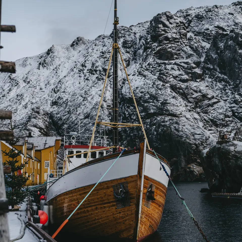 Bateau amarré, une grande montagne enneigée en arrière-plan