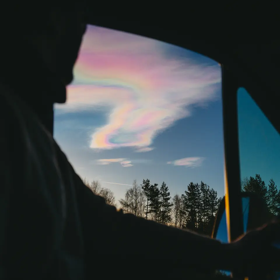 Udsigt fra et autocampervindue over iriserende skyer