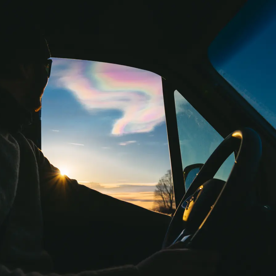 Udsigt fra et autocampervindue over iriserende skyer