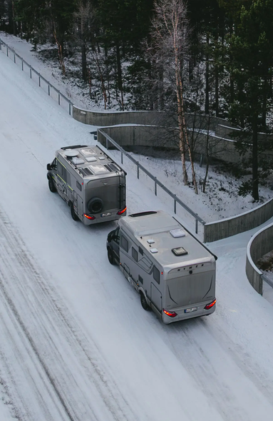 Luftudsigt over HYMER B-MC T BlackLine og HYMER ML-T 570 CrossOver, parkeret på en sneklædt vej