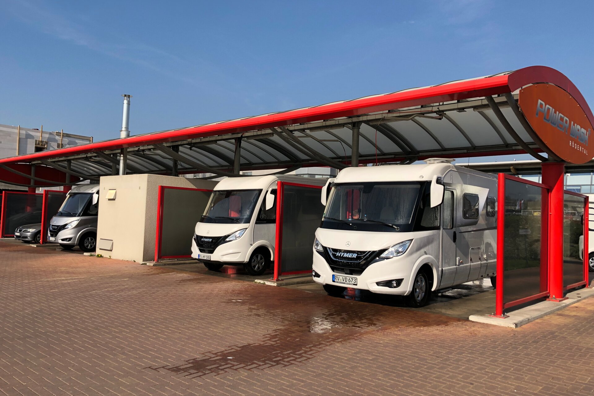 Three HYMER motorhomes next to each other in the car wash separated by walls