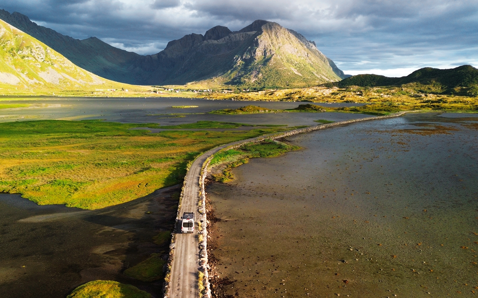 LMC Innovan Active aux îles Lofoten en Norvège. Route qui traverse les montagnes avec véhicule au milieu.